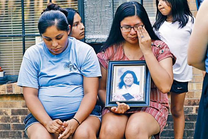 美国密西西比州两姐妹捧着死于新冠肺炎母亲的遗照。