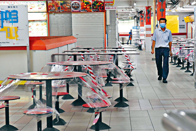 新加坡唐人街一个小贩中心近日封闭枱椅防疫。