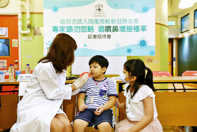 藥劑師示範為幼兒接種噴鼻式流感疫苗。