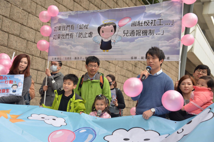 游行人士手持代表保护孩子的粉红色气球。