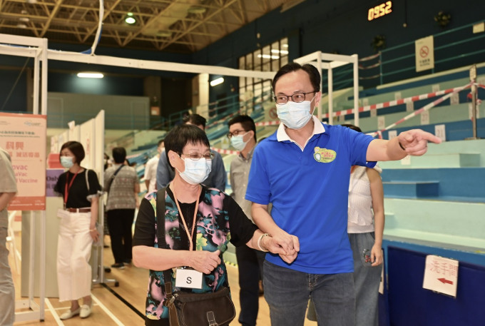 聶德權（右）與參加完健康講座的長者到九龍灣體育館社區疫苗接種中心接種科興疫苗。政府新聞處圖片