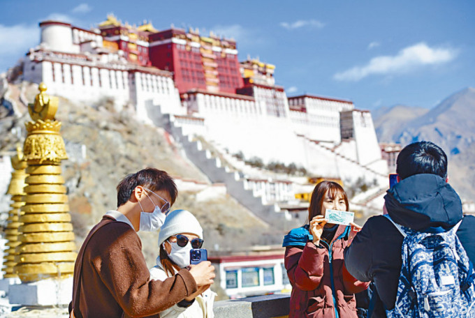 游客在西藏拉萨布达拉宫前合影。