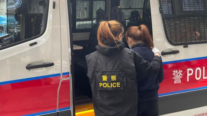 被捕的女子被帶上警車。