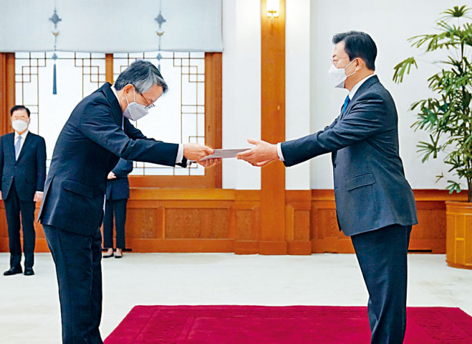 文在寅（右）昨日在首爾從日本大使相星孝一手中接過國書。