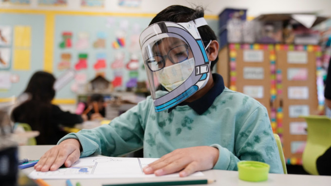 疫情期間，加州一名四年級生戴着面罩上課。 美聯社