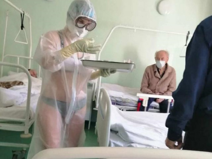 女护士身穿透明保护衣，而其里面却仅穿内衣裤去照顾男病人。网图