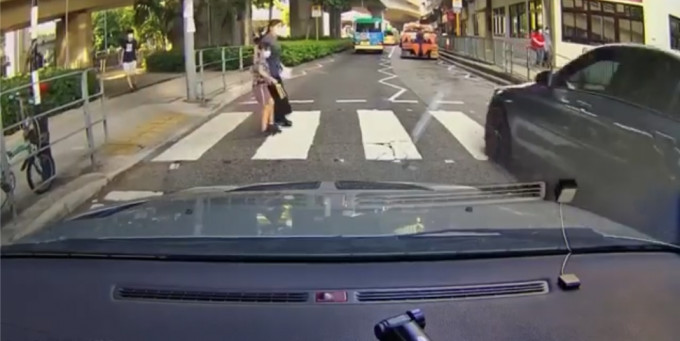 该对母女亦吓得立即停下，等待私家车横过后始续过马路。 影片截图