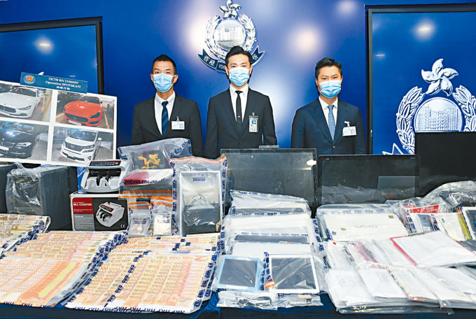 署理总警司何振东（中）讲述案情，并展示检获的现钞及电脑等证物。