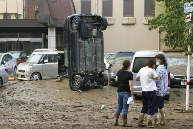 人吉市有汽车被洪水冲翻。AP图片