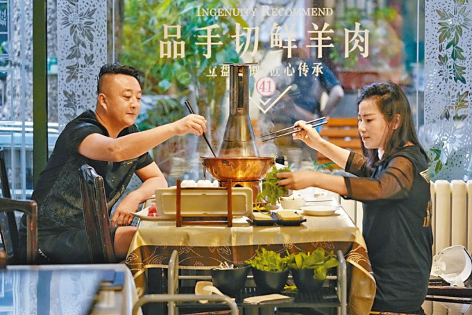 北京市民昨天到食府享用羊肉火鍋。
