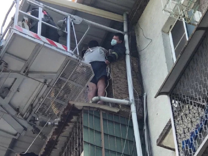 高雄男子危站在屋檐上，最后要由消防员架起云梯去拯救。（网上图片）