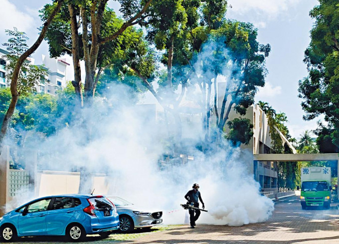 新加坡工人在社區噴灑殺蟲劑防止蚊患。