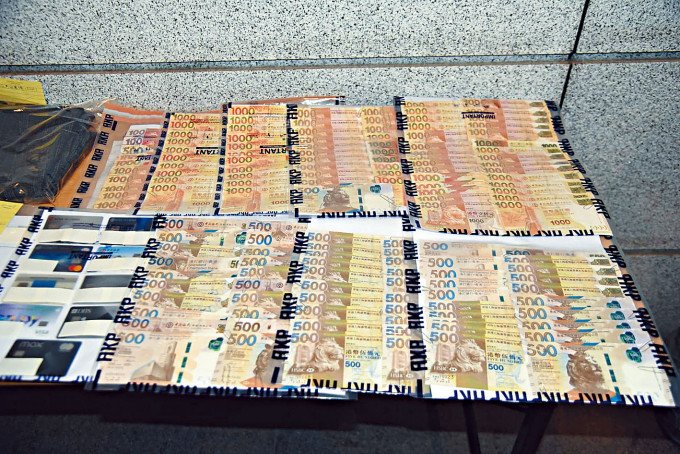 警方展示行动中起出现金及文件等证物。