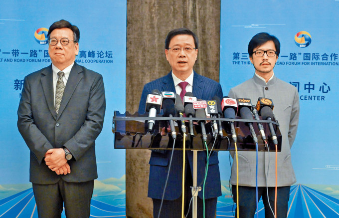 李家超（中）昨日在北京，聯同商務及經濟發展局局長丘應樺（左）和「一帶一路」專員何力治（右）會見傅媒。