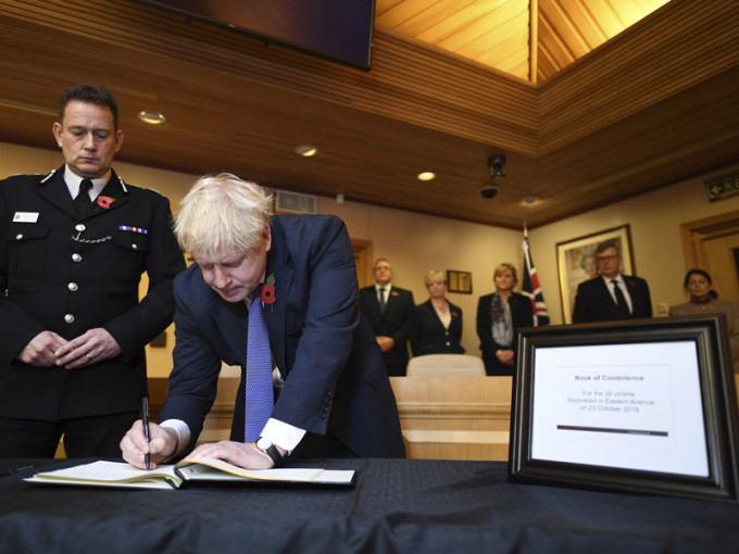 英國貨櫃車案司機提堂後繼續還柙，首相約翰遜簽署弔唁冊。AP