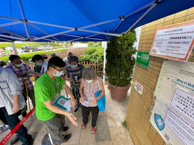 今早有約20名長者在九龍灣體育館社區疫苗接種中心外排隊，領取「即日籌」打針。