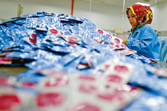 康乐公司职工在马来西亚的厂房包装避孕套。　