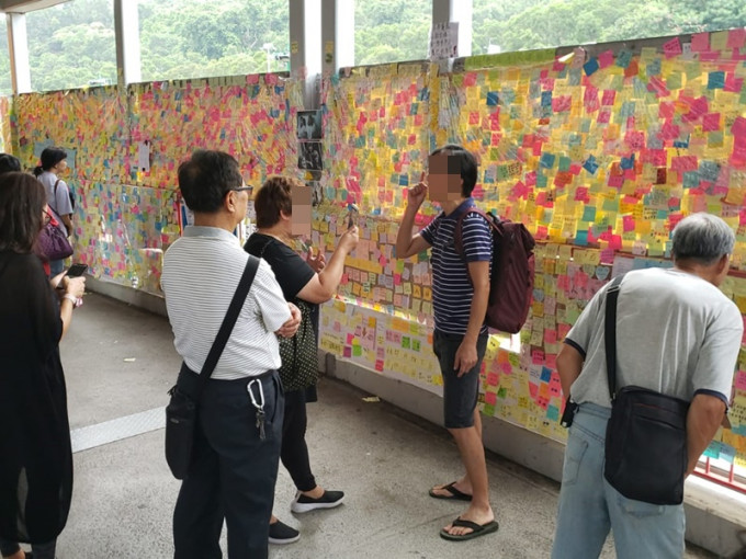 一名黑衣妇人贴上撑警标贴，遮盖原有标题，引起一名支持反修例男子不满。读者提供