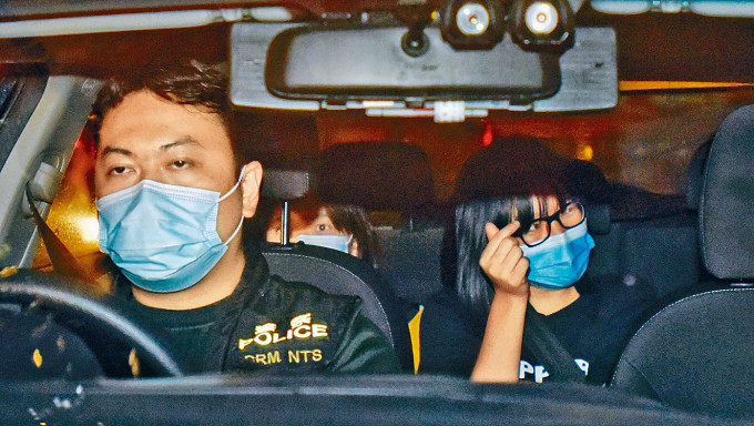 ■邹幸彤昨晚被押返荃湾警署时，向记者「派心」。