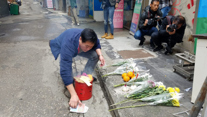 街坊张先生在场上香及拜祭。 杨伟亨摄