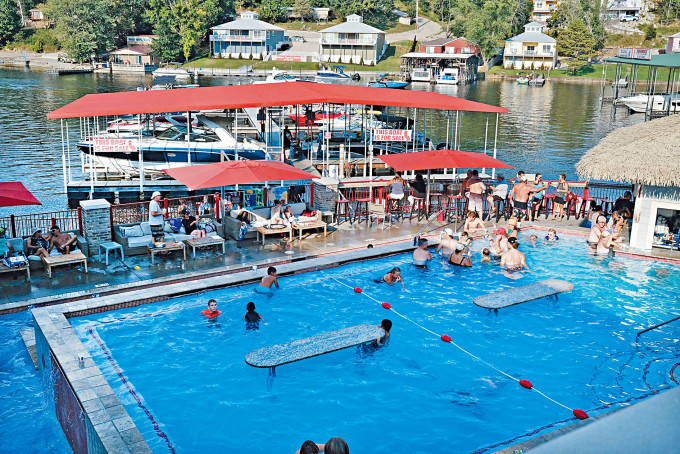 游客在密苏里州欧塞奇比奇市的游泳池和酒吧，享受午后时光。