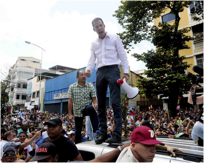 瓜伊多站在一条桥上以扬声器向支持者讲话。AP
