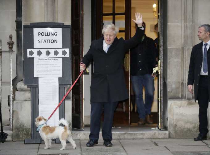 约翰逊携同爱犬到票站投票。AP