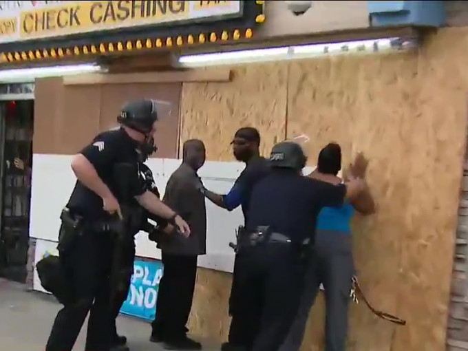 美國警察好人當賊辦，黑人制止搶劫反被警銬起，美國傳媒直播全拍下。（霍士新聞截圖）