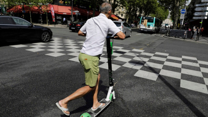 一名男子在巴黎踩滑板车。 资料图片