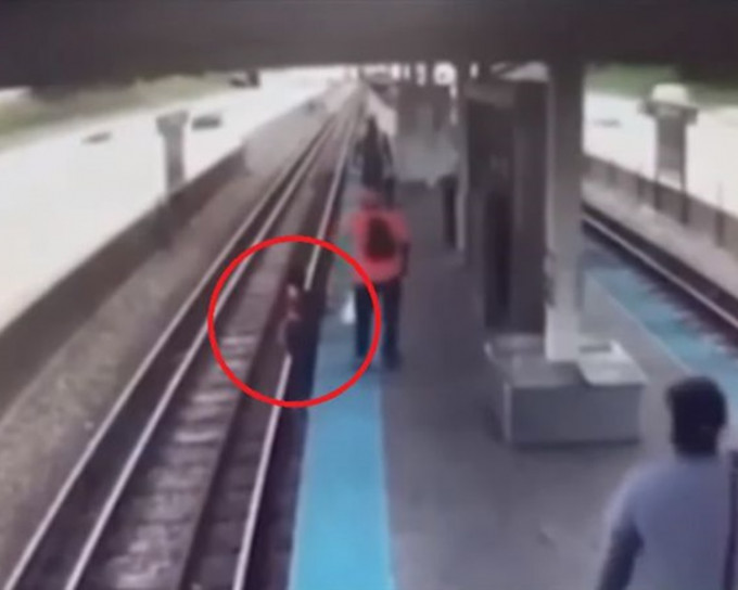 女子跳下了月台到路轨上捡回手机。网图