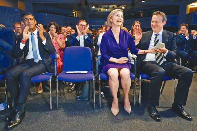 卓慧思在丈夫奥利里（右）陪伴下喜迎党魁选举胜利，对手辛伟诚（左）鼓掌祝贺。
