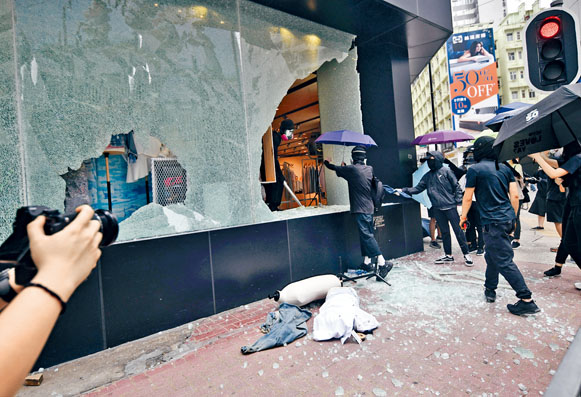 ■一批黑衣人打砸時裝店櫥窗，玻璃盡碎，更偷走衣衫。