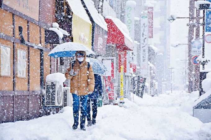 ■日本富山市周一大雪中的行人。