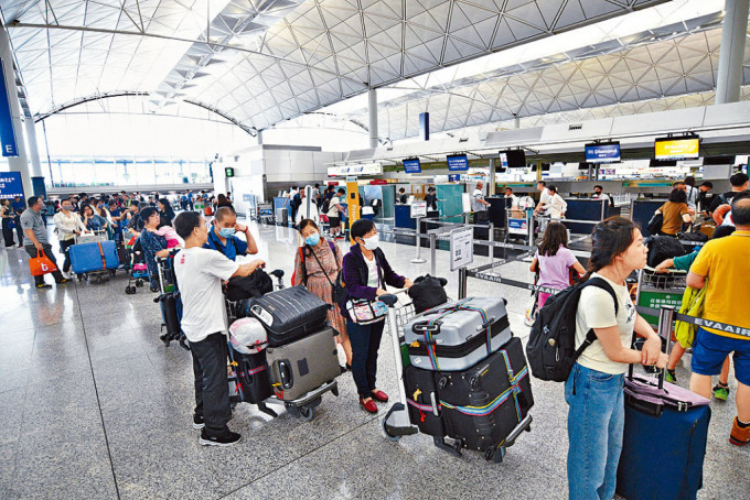 随台风逐渐远离本港，多班航班获准复飞，不少旅客在机场等候办理登机手续。