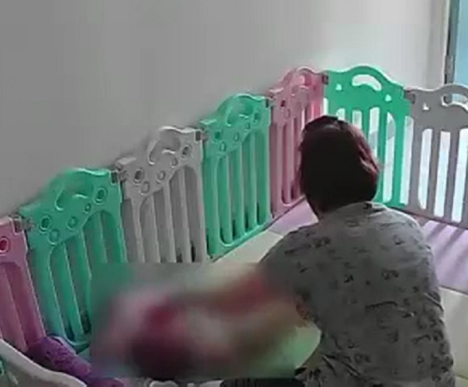 一名女子粗暴对待婴儿。影片截图