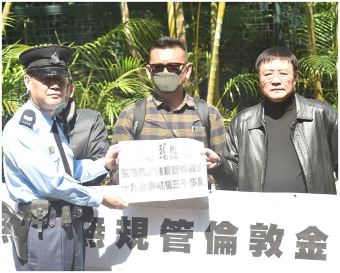 两名台湾的伦敦金骗案苦主携横额到礼宾府递交请愿信。
