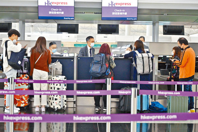 乘客在赤鱲角机场办理登机手续准备出发。
