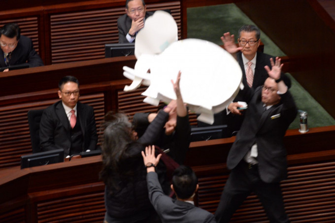 梁國雄在場內示威，拿著紙製大白象道具衝向陳茂波。
