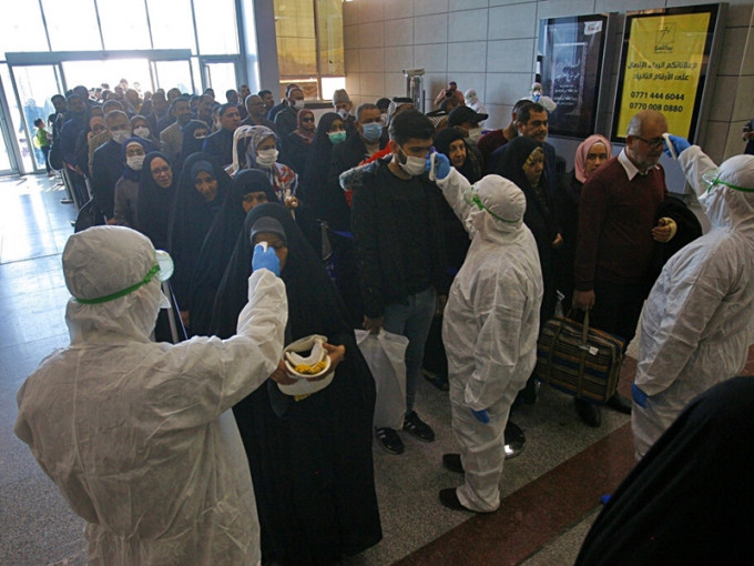 伊朗當地檢疫人員為民眾監測體溫。AP