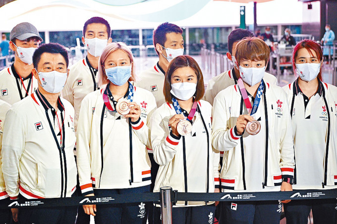 ■香港乒乓球队成员苏慧音（前排左二）、李皓晴（前排中）与杜凯琹（前排右二）拿着铜牌让记者拍照。