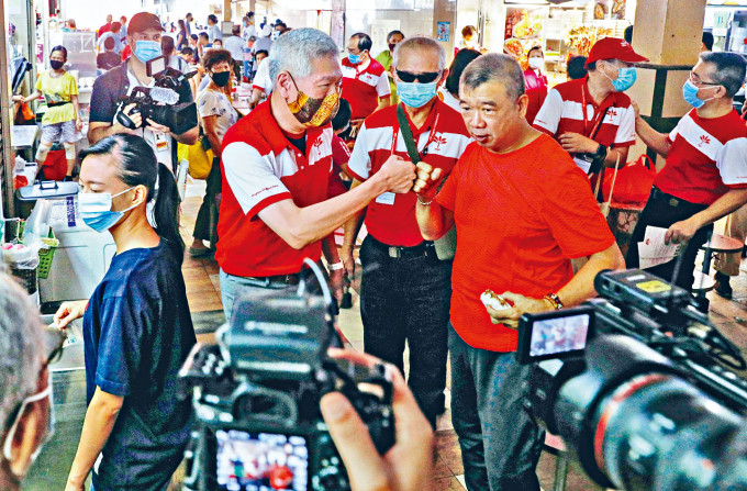 已加入新加坡前进党的李显扬(中左)，周日落区与民众近距离接触。