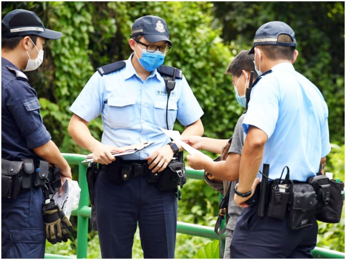 警方在行動期間，票控兩名無戴口罩的男子。