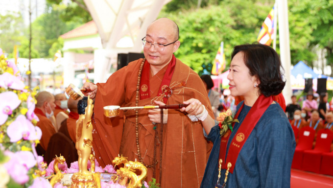 宏明法师陪同麦美娟浴佛。