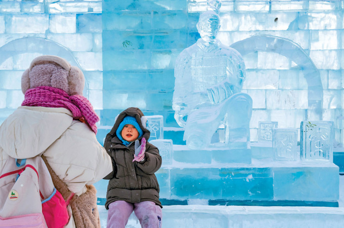 遊客在哈爾濱「冰馬俑」冰雕前拍照。