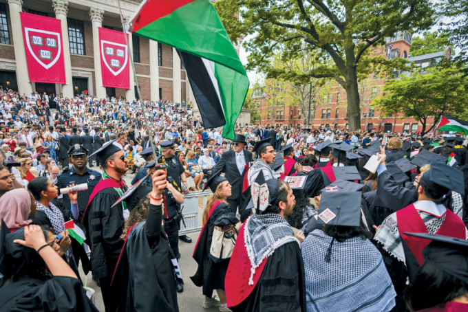 哈佛毕业礼上，离场抗议的学生举起巴勒斯坦旗帜及高呼口号。