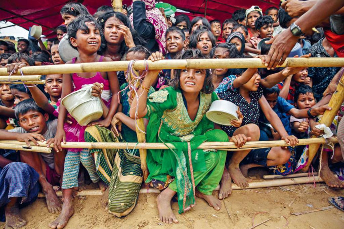 罗兴亚孩童在孟加拉难民营等分发食物。