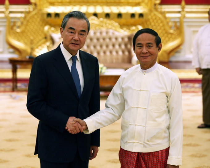 缅甸总统温敏（右）会见王毅。 新华社