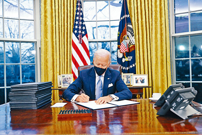 拜登周三在白宮橢圓形辦公室簽署行政命令。