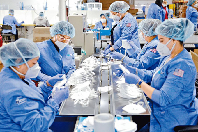 美國新澤西州帕特森一批工人，上周四在廠房內生產N95口罩。