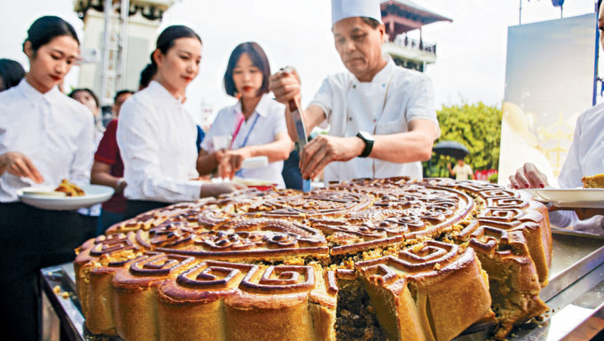 中秋将至，广西合浦县月饼师傅在分切大月饼。